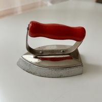 Altes Bügeleisen mit rotem Griff, Kinderspielzeug
