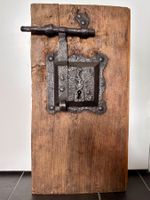Antikes handgeschmiedetea Türschloss auf Holzbrett