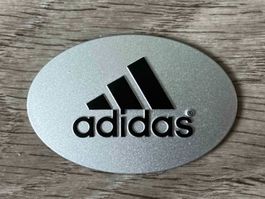 adidas Schild Kunststoff / oval / 5,4 cm breit / 3,6 cm hoch