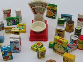 Vintage Spielzeugwaage mit zahlreichen Miniaturverpackungen