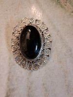 Es ist eine silversterling Brosche mit einem  Obsidianstein.
