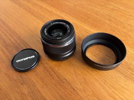 Olympus 25mm, Blende 1.8 schwarz mit Gegenlichtblende