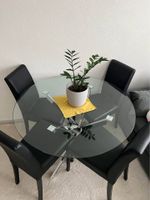 Table ronde en verre et de 4 chaises noires en cuir