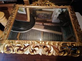 Imposant miroir en bois dorés, sculptés et moulurés.