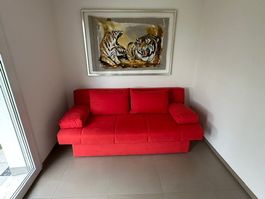 Rotes Sofa mit Schlaffunktion