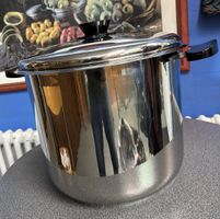 Topf aus poliertem Edelstahl mit schwarzen Griffen und Decke
