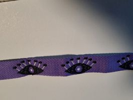 Lila Webband mit Augenmotiv