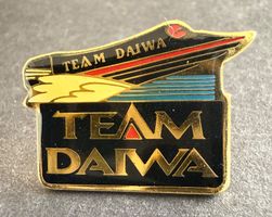 Pin’s Team Daiwa doré logo pêche