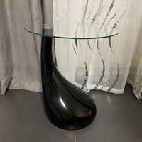 Tavolino di design nero scultoreo con piano in vetro