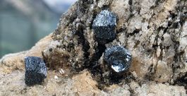 Mineralien: Hämatit (Eisenrosen) mit Quarz und Titanit.