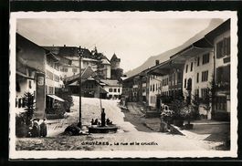 Gruyères, la rue et le crucifix, quelqu