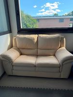 Divano 2 posti in pelle color panna/beige.