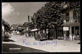 AK Schwarzenburg, Straßenpartie mit Geschäften und parkendem