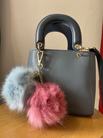 Kleine graue Handtasche mit Pompons