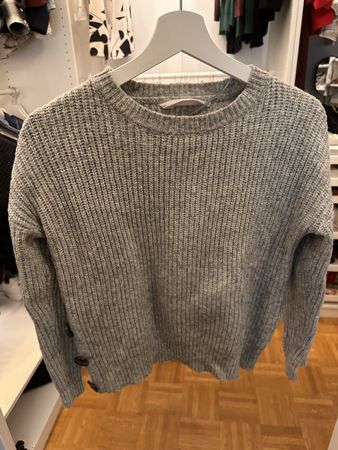 Grauer Strickpullover mit Knopf-Detail