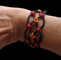 Schönes handgefertigtes Armband mit Blumen. Schwarz rot