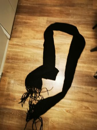 Warmer Herbst-Look: Schwarzer Strickschal mit Fransen.