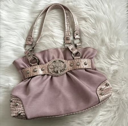 Sac à main rose orné d'une boucle décorative et de clous