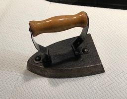 Antikes, kleines Bügeleisen aus Gusseisen mit Holzgriff
