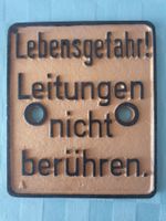 Schild Lebensgefahr! Leitungen nicht berühren.