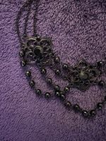 Schwarze Kette, blumenartige Elemente & schwarze Steinchen