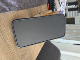 iPhone 15 Pro Max 256 Go graphite avec écouteur et coque.