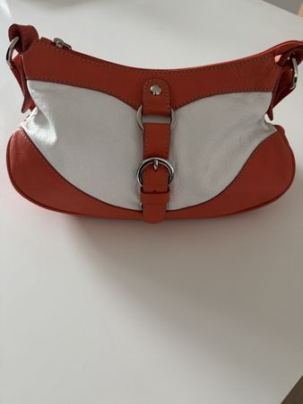 Sac Coccinelle en cuir orange et blanc, porté épaule