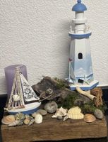Deko Leuchtturm mit Segelboot und Muscheln auf Holz