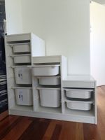 Weißes Regal mit Aufbewahrungsboxen
