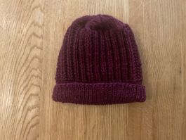 Handgestrickte, warme Wintermuetze in schoenem Weinrot