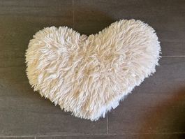Weisses, flauschiges Kissen in Herzform