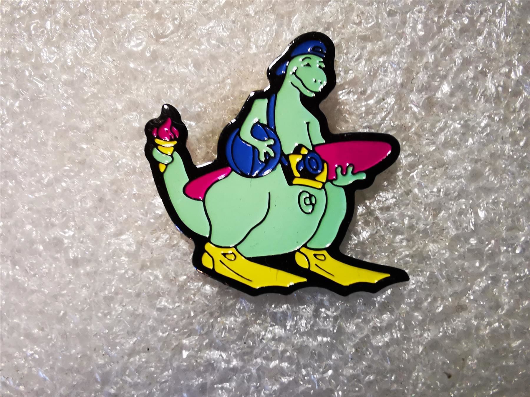 Placchette & Badge: Ansteckpin 9: Dinosaurier mit Surfboard – Usato da Oppligen venduto da Pin-Fall-Shop