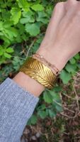 Bracciale rigido dorato effetto piuma regolabile