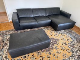 Schwarzes Ledersofa inkl. Hocker