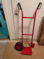 Roter Sackkarre mit einem Pneu