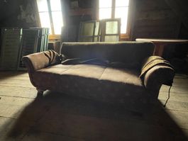 Gut erhaltenes antikes Sofa mit schönen Mustern drauf.