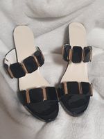 Elegante schwarze offene High Heels mit goldenen Details