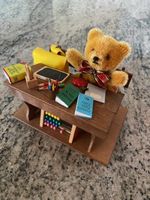 Kleiner Teddy mit Schulbank und Miniaturen