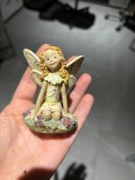 Petite figurine de fée assise en résine décor floral