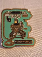 Pin Telephonica Motiv Telefon goldfarben