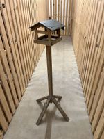 Vogelhaus aus Holz mit Schiefer-Dach auf Ständer