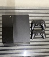 PlayStation 4 mit zwei Controllern und Spielen