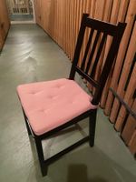 gut erhaltener Esszimmerstuhl mit rosa Sitzkissen.