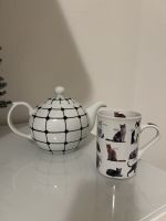Teekanne mit Muster und Tasse mit Katzenmotiv