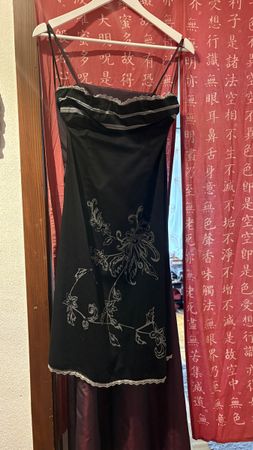 Robe noire courte à fines bretelles et motifs floraux