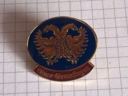 Pin's avec aigle bicéphale et inscription difficile à lire