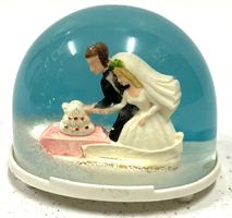 Schneekugel mit Hochzeitspaar und Torte