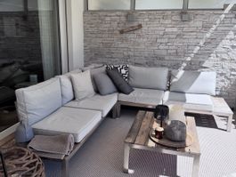 Lounge-Ecke Sofa, mit Tisch. Grau, Holz, Edelstahl.