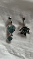 Zwei Bauchnabelpiercings, mit blauen Strasssteinen