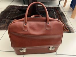 Valigia vintage in pelle marrone con scomparto inferiore